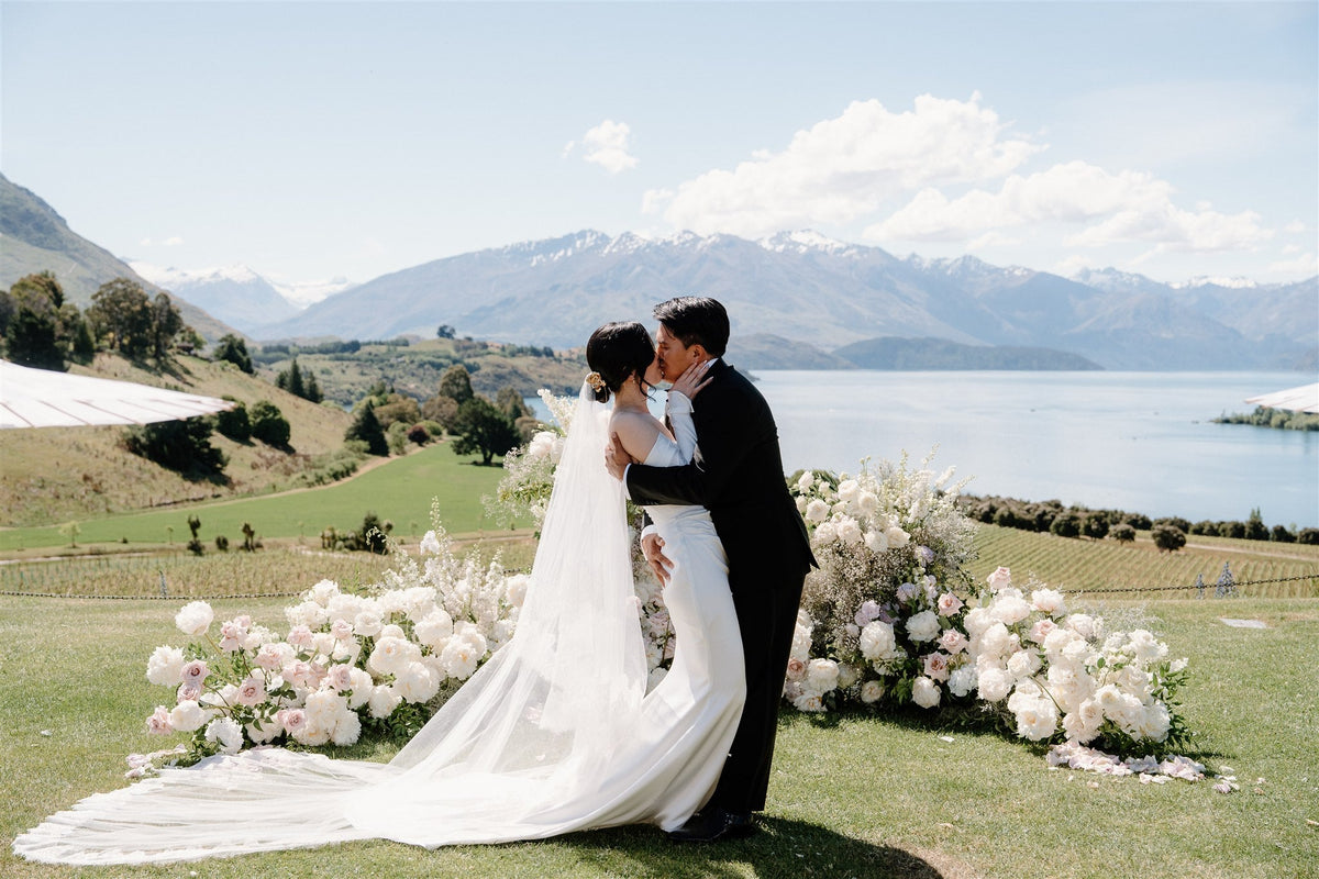 Bride and groom in front of alpine floral landscape on wedding day